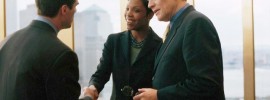 People shaking hands in a business setting and smiling